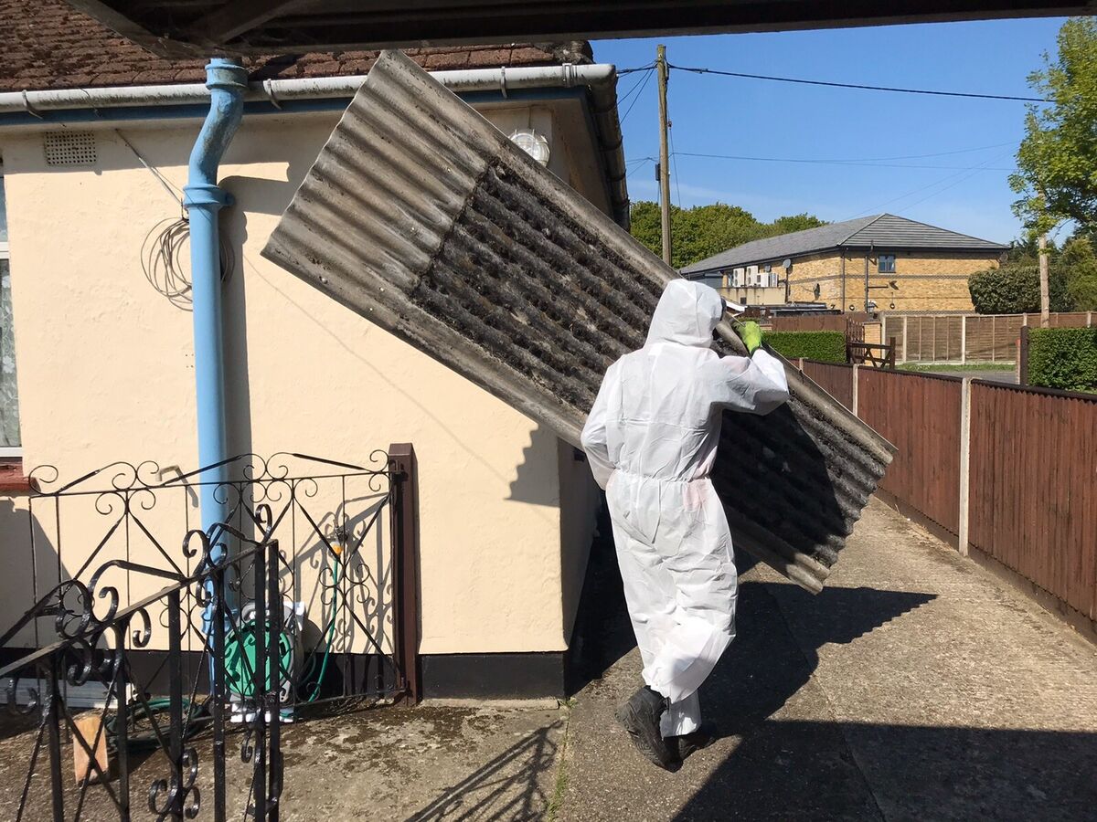 Asbestos disposal operatives collecting sealed waste in London